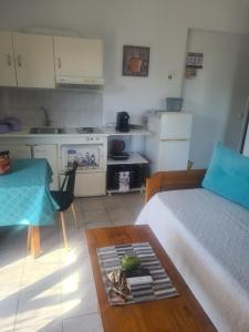 a room with a bed and a table and a kitchen at SPITIKARIOTIKO Panoramic Home in Raches