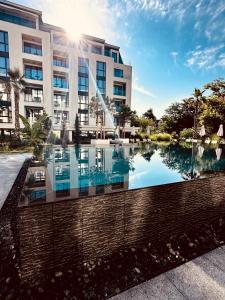 - un bâtiment avec une piscine réfléchissante en face dans l'établissement Azur Premium Resort, à Saints Constantine et Helena