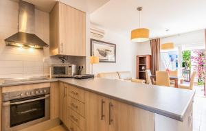a kitchen with wooden cabinets and a counter top at Nice Apartment In Alhama De Murcia in Alhama de Murcia