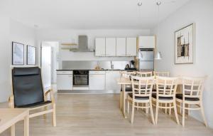 a kitchen and dining room with a table and chairs at Gudhjem Søpark Lejl 23 in Gudhjem