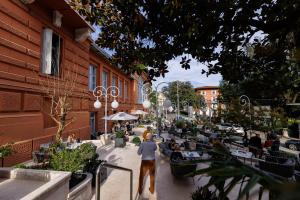 a man walking down a street with people sitting at tables at Hotel Imperial - Liburnia in Opatija