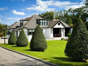 una casa bianca con alberi di fronte di Large and luxurious country home near Glasgow a Eaglesham