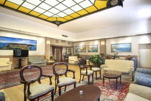 a lobby with chairs and tables and a television at Grande Albergo in Sestri Levante