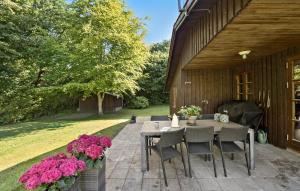 a patio with a table and chairs and flowers at 3 Bedroom Nice Home In Farsø in Farsø