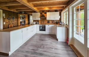 eine Küche mit weißen Schränken und einer Holzdecke in der Unterkunft 4 Bedroom Lovely Home In Hovet in Hovet