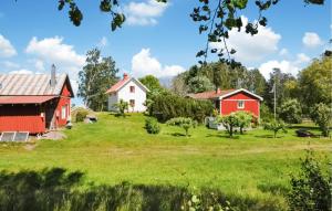 two red and white houses on a green field at 2 Bedroom Awesome Home In Kristinehamn in Edet