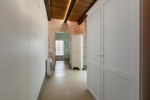 a hallway with a white door and a room with a hallway at Dimore Briganti in Gallipoli