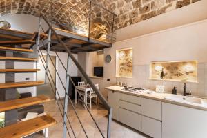 a kitchen with a staircase leading up to a loft at TEMPO DI NOTO in Noto +30 photos