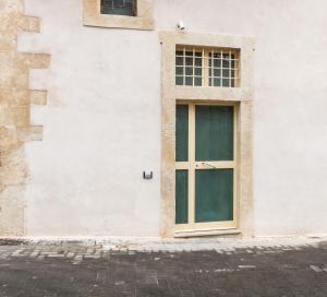 a door on the side of a white building at TEMPO DI NOTO in Noto