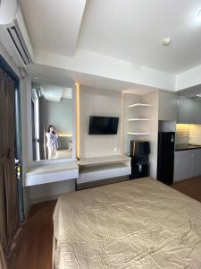 a bedroom with a bed and a person taking a picture at Monroe Tower Apartment By Kyra Property in Pegadungan