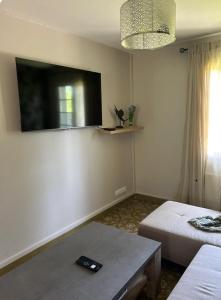 a room with two beds and a table and a tv at Enosis in Port-en-Bessin-Huppain