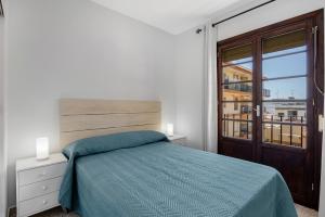 a bedroom with a bed and a large window at Chipiona Centro y Playa in Chipiona