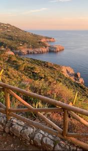 een hek op een heuvel met uitzicht op de oceaan bij Villa Pineta - Holiday House in Anacapri
