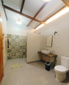 a bathroom with a toilet and a sink at BaraCoco Bungalows in Bira