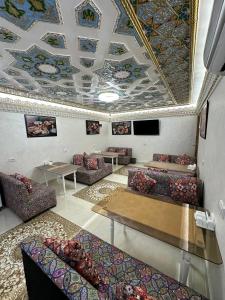 a living room with couches and tables and a ceiling at SILVER Terrace in Bukhara