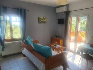 a living room with a couch and a chair and a balcony at SPITIKARIOTIKO Pergola Home in Raches