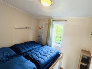 Zimmer mit einem blauen Bett vor einem Fenster in der Unterkunft RBR 237 - Beach Resort Kamperland in Kamperland + 7 Fotos