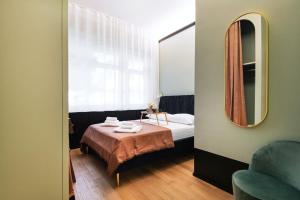una piccola camera da letto con un letto e uno specchio di Easylife - Milano - Vittore 45 I - Sant'Ambrogio a Milano