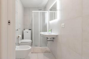 a white bathroom with a toilet and a sink at H11 LUXURY 3B - Porto - Piscina - Jacuzzi in Santo Stefano al Mare