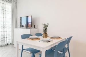 a dining room with a white table and blue chairs at H11 LUXURY 3B - Porto - Piscina - Jacuzzi in Santo Stefano al Mare