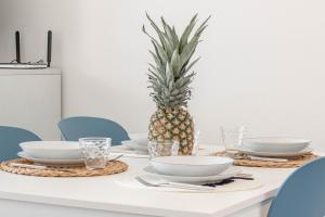 a table with plates and bowls and a pineapple on it at H11 LUXURY 3B - Porto - Piscina - Jacuzzi in Santo Stefano al Mare
