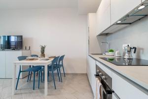 a kitchen with a table and chairs in a room at H11 LUXURY 3B - Porto - Piscina - Jacuzzi in Santo Stefano al Mare
