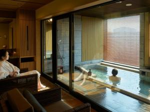 青森ReLabo -Medical Spa & Stay-的一位女士坐在酒店房间的浴缸里 更多37张照片