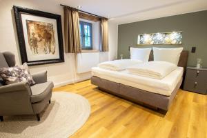 a bedroom with a large bed and a chair at Michels Mühle - Pitt sin Atelier in Brilon
