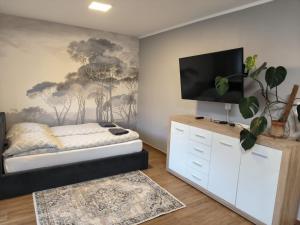 a bedroom with a bed and a flat screen tv at Apartament 25 Mikołajki in Mikołajki