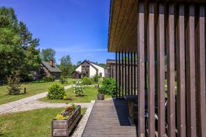 a wooden walkway next to a house with a yard at Rīteņi in Ķesterciems