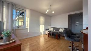 a living room with a couch and a table at Chillout u Oli Apartament nad samym jeziorem in Ostróda +2 photos