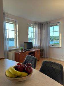 a room with a table with a bowl of fruit on it at Chillout u Oli Apartament nad samym jeziorem in Ostróda
