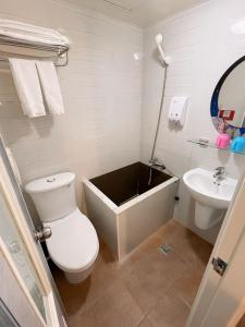a bathroom with a tub and a toilet and a sink at Dealer Hotel in Taipei +51 photos
