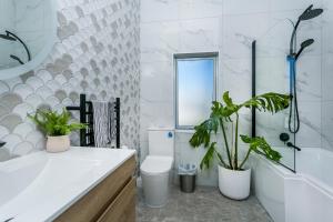 bagno con servizi igienici e 2 piante in vaso di Eden St Lukes Cozy Accommodation ad Auckland Altre 33 foto