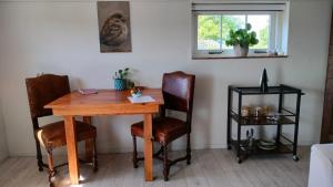 a wooden table and chairs in a room with a window at Bed and Breakfast Hammerhoeve in Lunteren