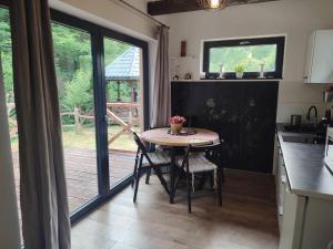 a kitchen with a small table and a patio door at Bieszczadzkie Asy in Polana