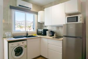 a kitchen with a washing machine and a window at Apartamento con terraza en la playa in Cala del Moral +13 photos