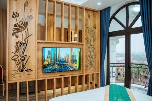 ein Schlafzimmer mit einem TV an einer Holzwand in der Unterkunft Gala Hotel & Apartment in Haiphong