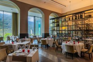 a restaurant with tables and chairs and shelves of wine bottles at Grand Hotel Billia in Saint Vincent