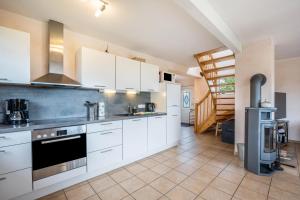 a kitchen with white cabinets and a stove at Ferienwohnung Lichtblick in Grömitz