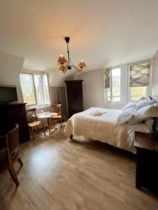 a bedroom with a bed and a tv and windows at Logis H&ocirc;tel De La Chapelle in Milon-la-Chapelle
