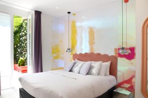 a bedroom with a large bed with a painting on the wall at Le Glam's Hotel in Paris