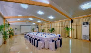 a large banquet hall with a long table with blue chairs at TreeHouse Neptune in Panaji