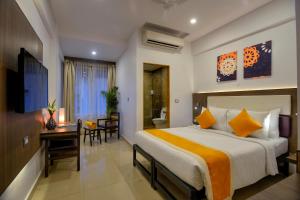 a bedroom with a bed and a desk and a bathroom at TreeHouse Neptune in Panaji +24 photos