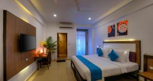 a hotel room with a bed and a television at TreeHouse Neptune in Panaji