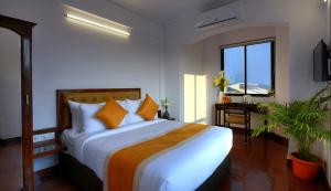 a bedroom with a large bed and a window at TreeHouse Neptune Inn in Panaji