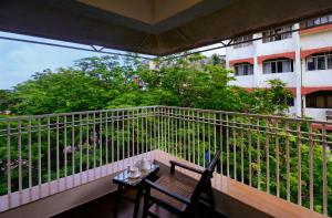 a balcony with a table and chairs and a building at TreeHouse Neptune in Panaji