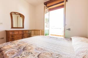 ein Schlafzimmer mit einem großen Bett mit einem Spiegel und einem Fenster in der Unterkunft Sisters` house by BarbarHouse in Marina di Mancaversa