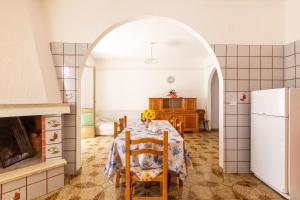 ein Esszimmer mit Tisch und Kühlschrank in der Unterkunft Sisters` house by BarbarHouse in Marina di Mancaversa