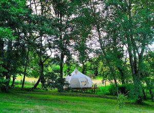 a tent in the middle of a field with trees at Nuit étoilée en pleine Nature in Solignac +9 photos